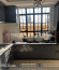 A completed modern kitchen featuring premium grey and white custom cabinets, marble countertops, a pull-out pantry, stylish backsplash, and integrated storage accessories.