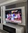 Modern living room featuring a floating TV wall unit, marble feature wall, fluted panels, LED lighting